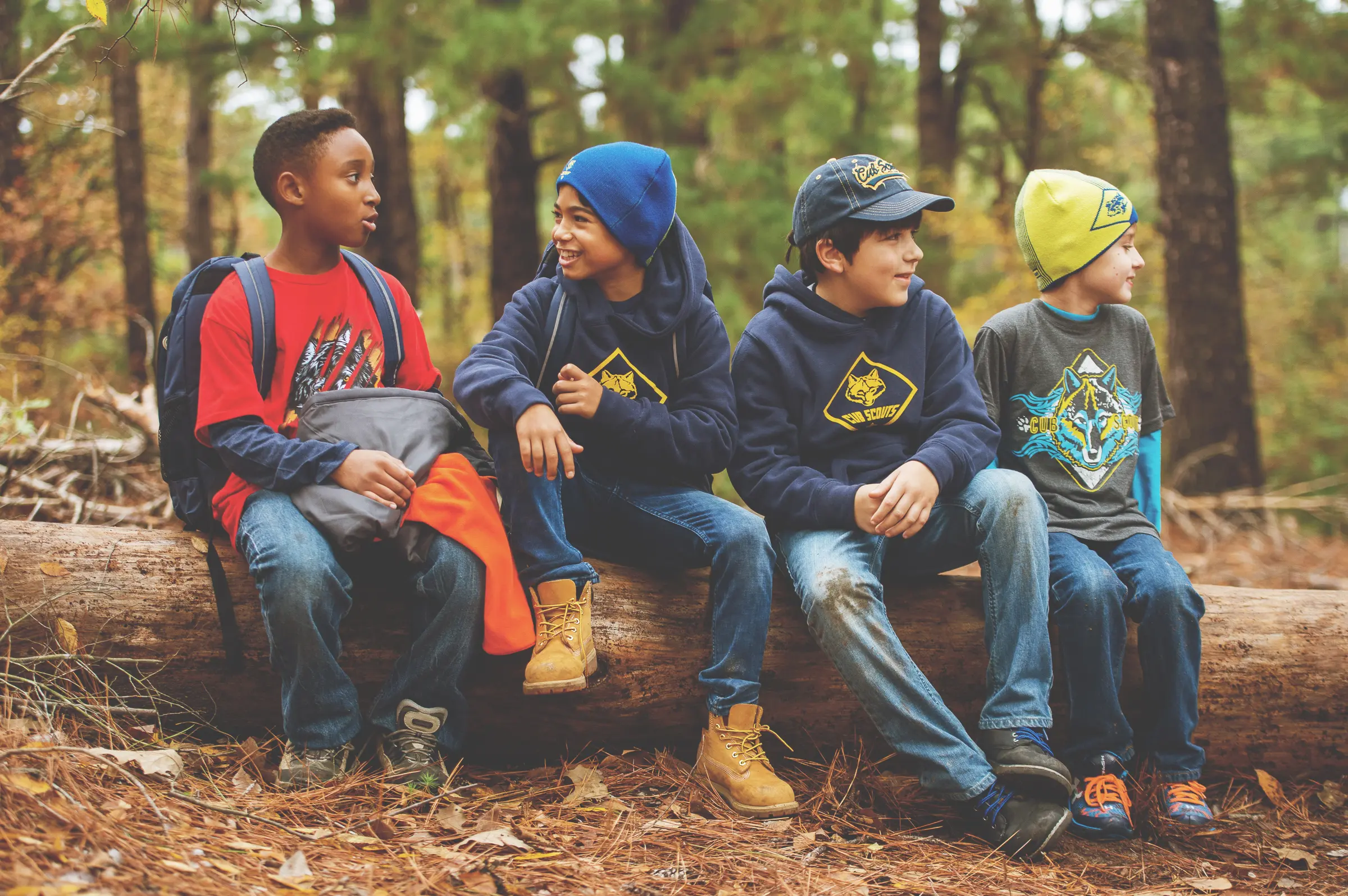 Cub Scouts sitting on a log in the woods